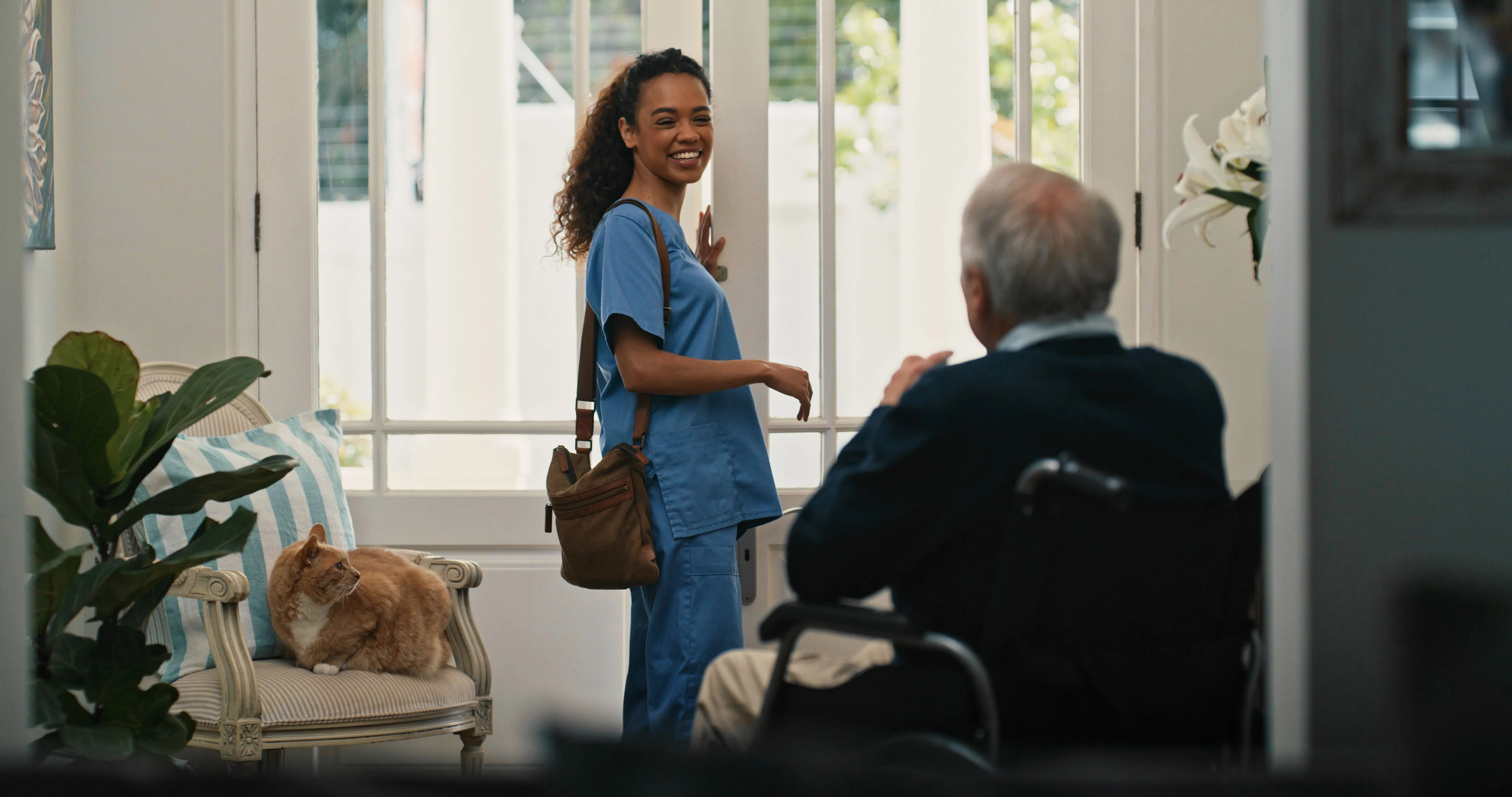 A professional caregiver greeting an elderly man in his Northern Michigan home